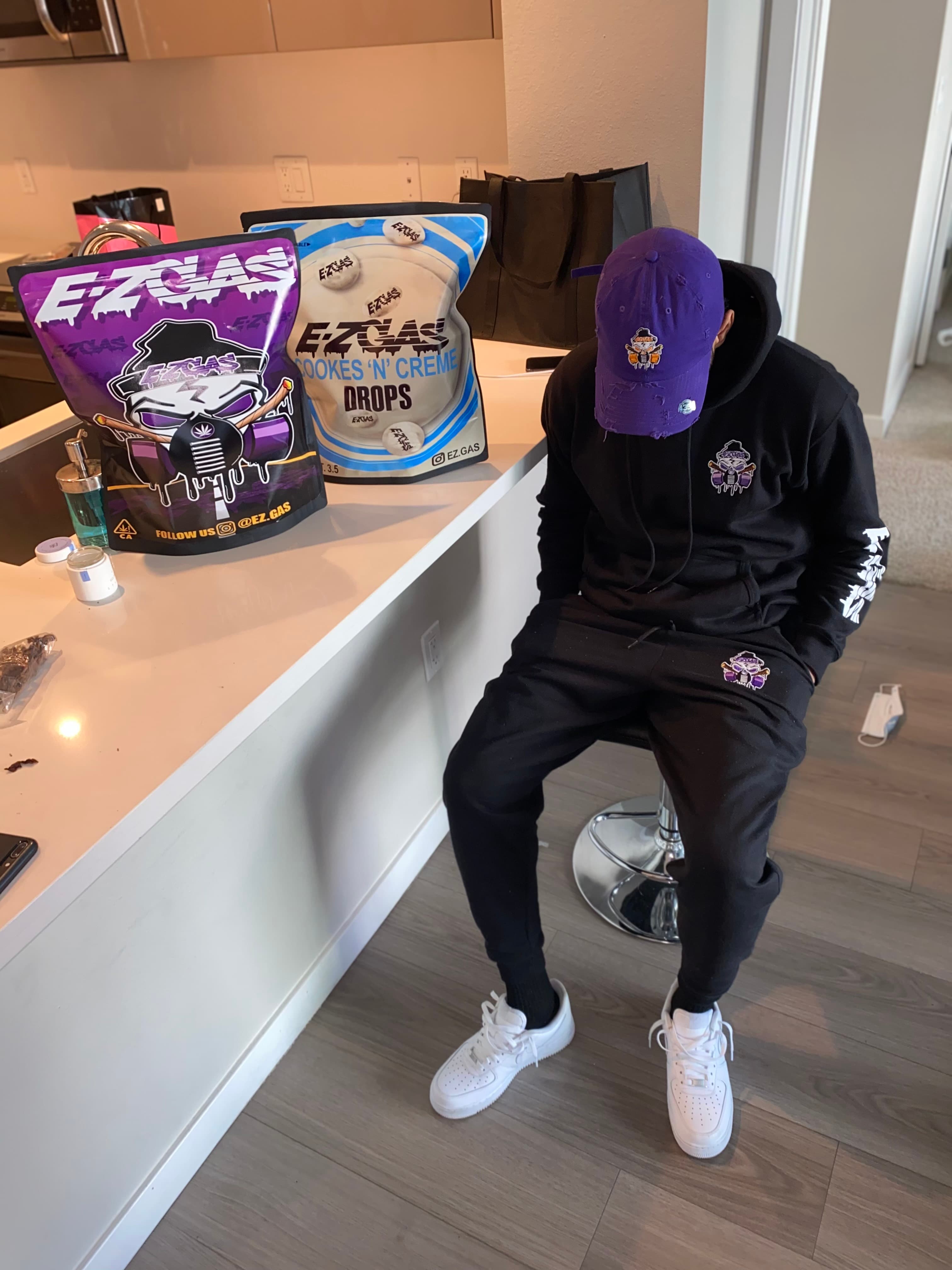 EZ in branded hoodie with product bags